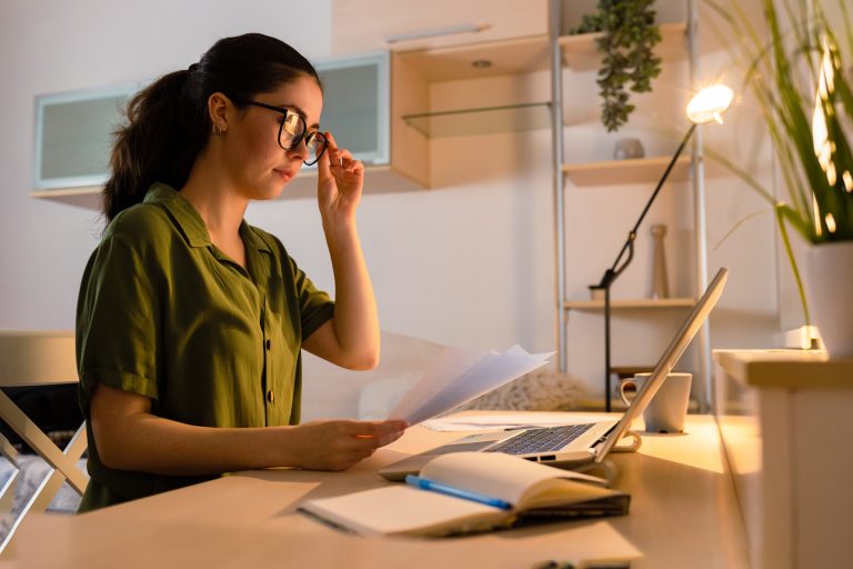 young woman wearing glasses working at laptop