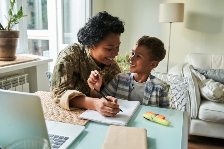 Mother plays tic-tac-toe with boy at table